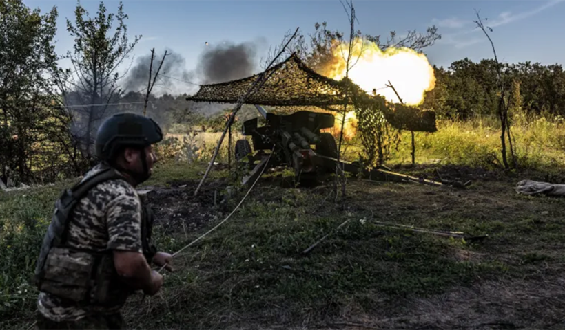 جندي أوكراني يقصف خنادق للقوات الروسية بالمدفعية (الأناضول)