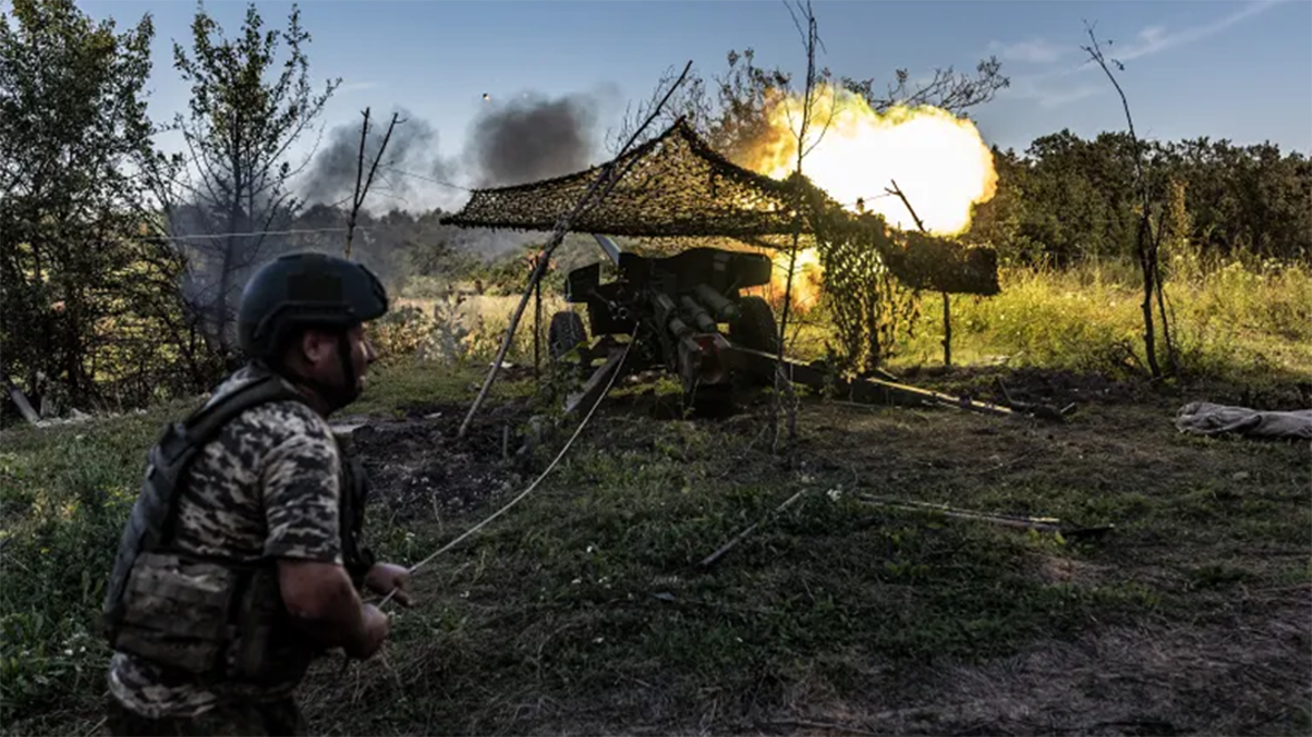 جندي أوكراني يقصف خنادق للقوات الروسية بالمدفعية (الأناضول)